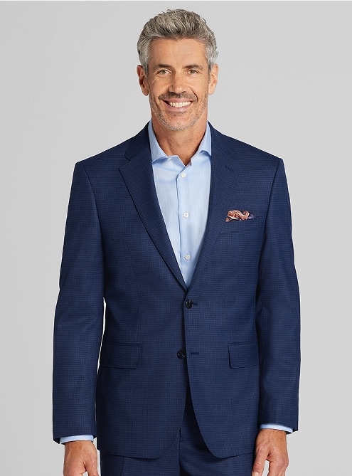 Man in a navy suit and light blue dress shirt. Clearance suits.