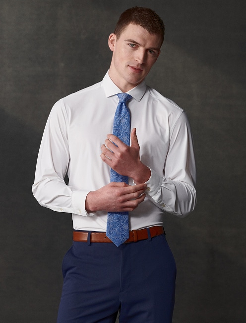 Man in a white dress shirt and patterned blue tie. Dress shirts 30 percent off.
