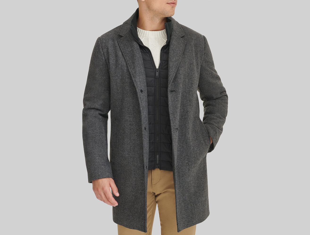 Man in a charcoal overcoat, vest, and sweater