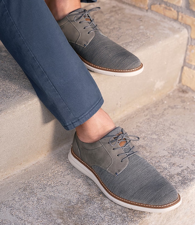 Navy trousers and grey lace-up shoes on steps