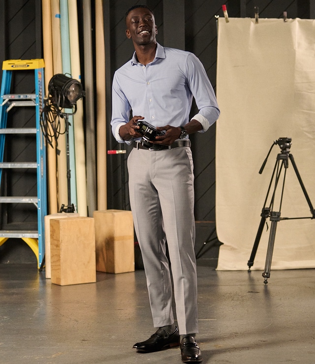 Man in a light blue shirt and jeans with white sneakers