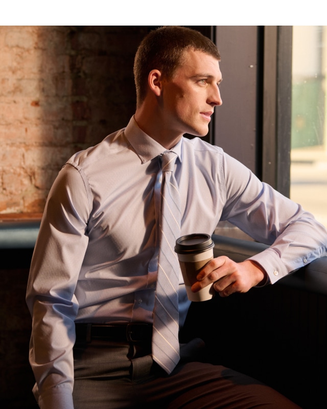 Man in light blue dress shirt and striped tie. Dress shirts up to 30% off.
