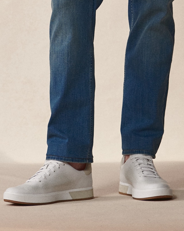 Close-up of jeans and white sneakers. Online only shoes 30 percent off.