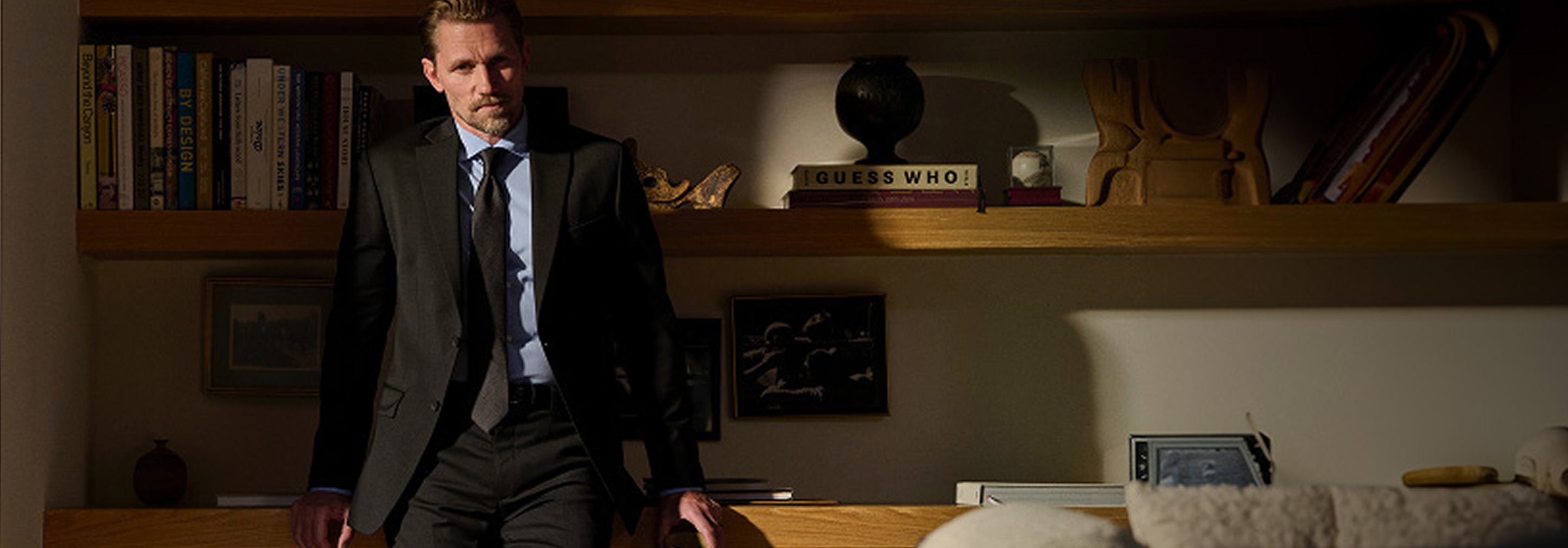 Man in suit standing by shelves with new looks headline and shop now button