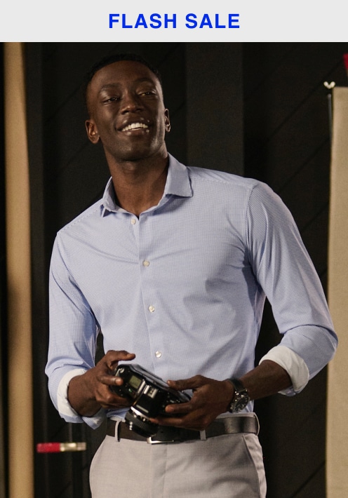 Flash sale. Man in a light blue dress shirt holding cufflinks. Dress shirts 30 percent off.
