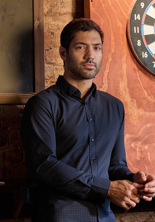 Man in a navy pin-dot casual shirt.