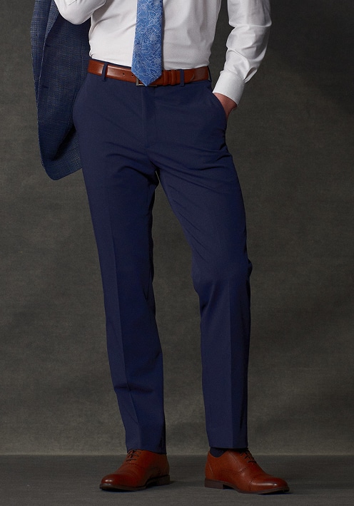 Man in navy dress pants with a belt and brown dress shoes.