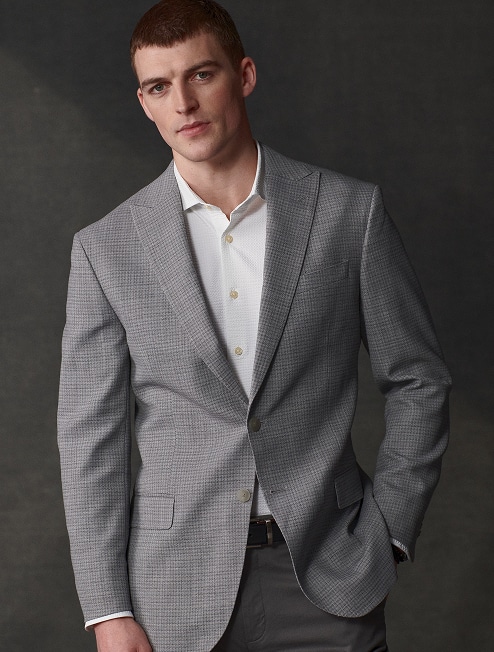Man in a grey checked sport coat over a white dress shirt.