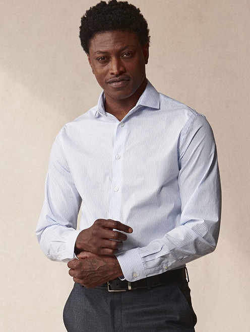 Man wearing a light blue striped dress shirt.