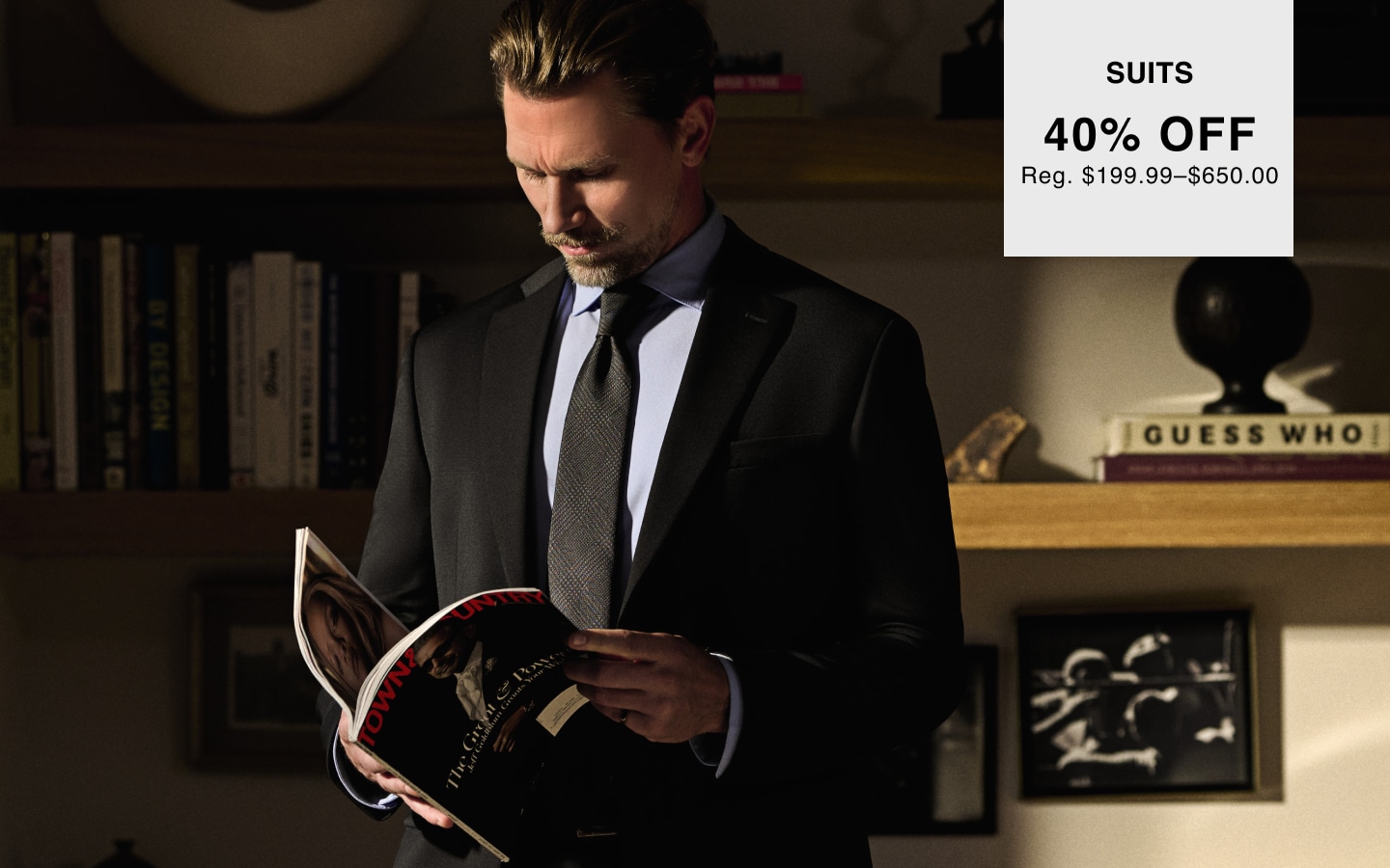 Man wearing a black suit. Suits 40% off. Regular price $199.99 to $650.00.