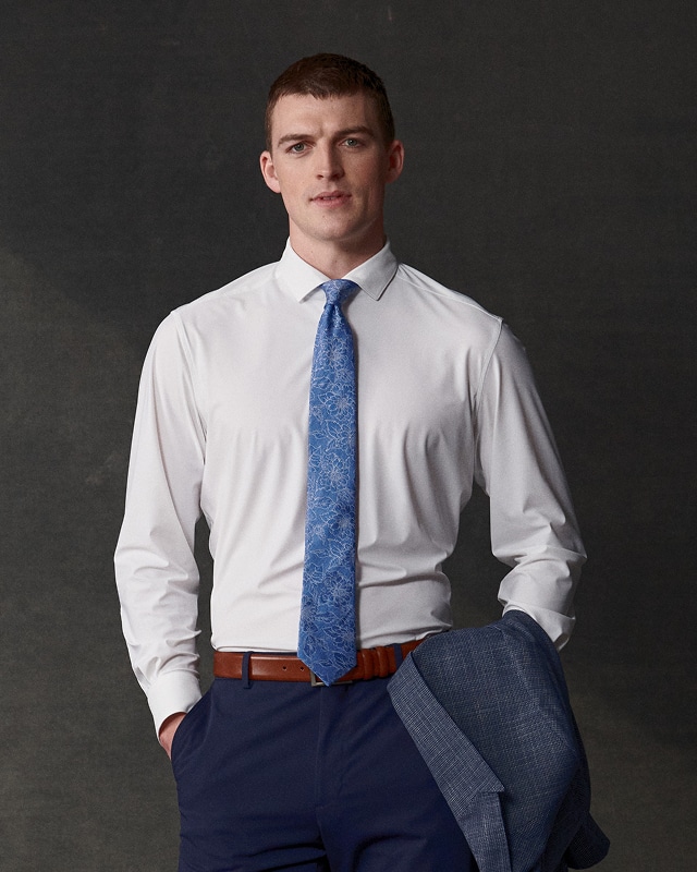 Man wearing a white dress shirt and blue tie. Dress shirts up to 40 percent off.