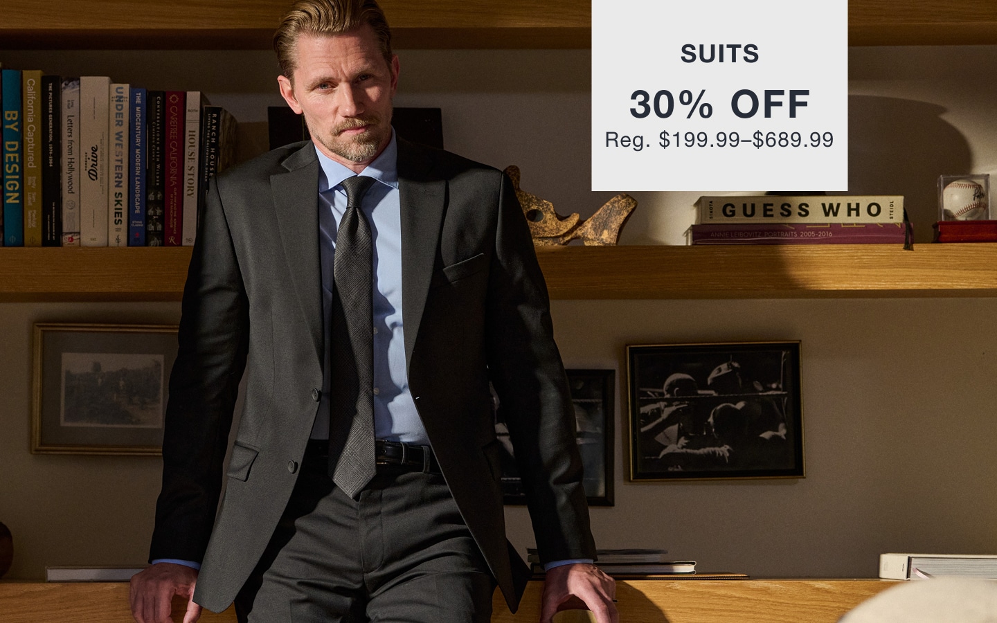 Man wearing a dark suit. Suits 30% off. Reg. $199.99–$689.99.