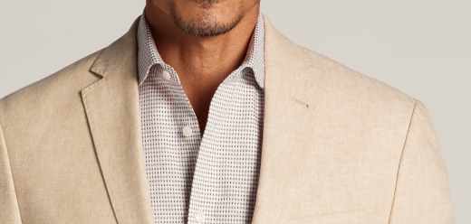 Man wearing a tan linen sport coat over a light dress shirt