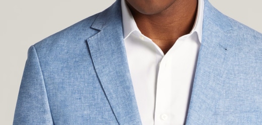 Man wearing a light blue linen suit jacket over a white dress shirt