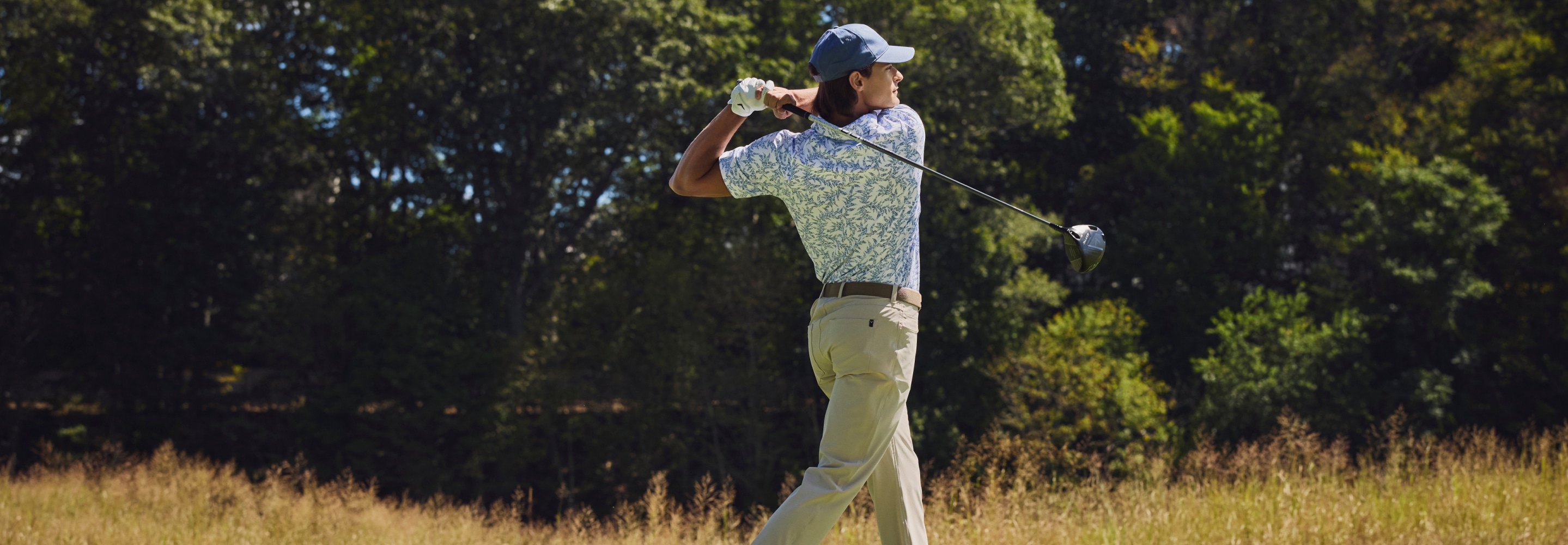 Golfer in blue polo on the course. Dad-worthy gifts for Father's Day.