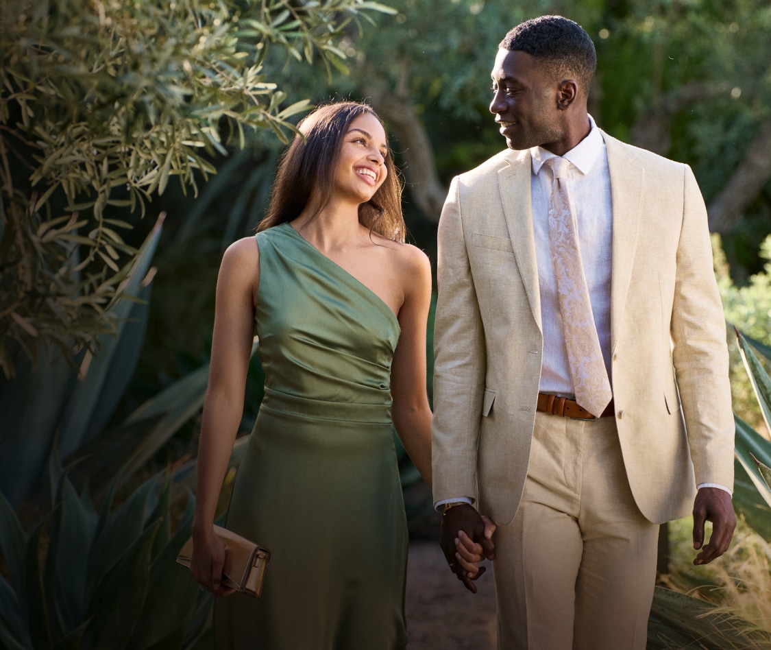 Couple outdoors — man in tan linen suit, woman in dress