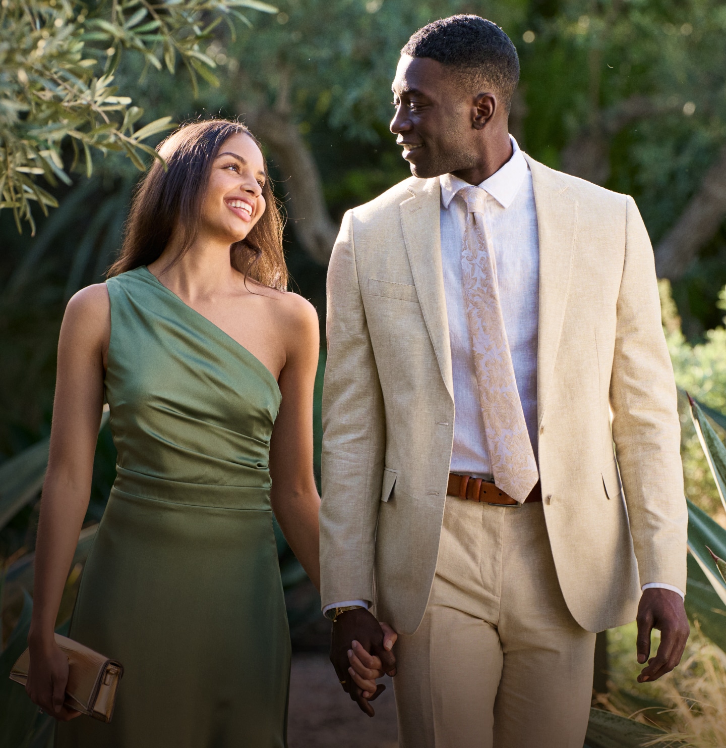 Couple outdoors — man in tan linen suit, woman in dress
